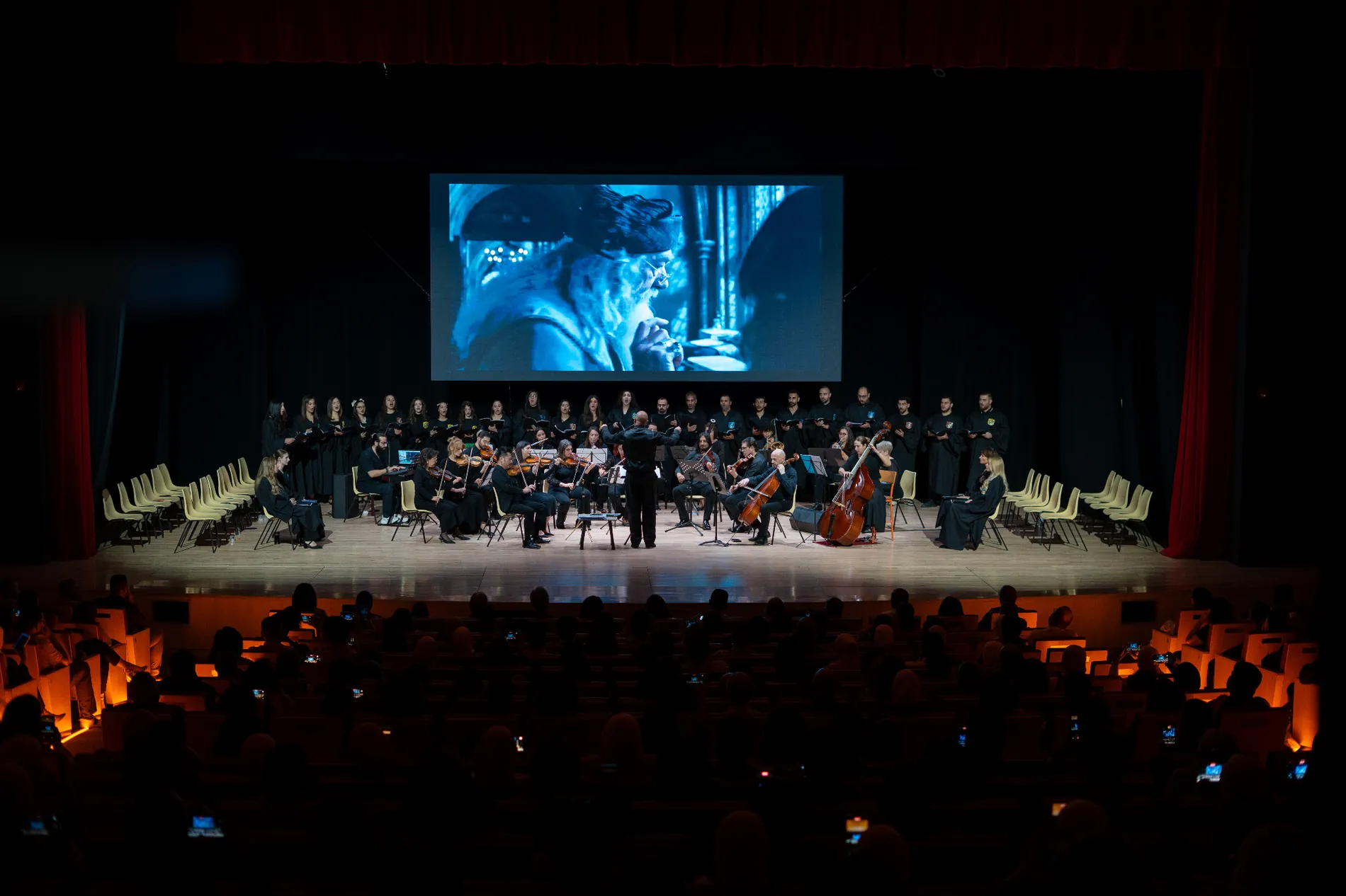 Orchestra and choir performing onstage for an audience